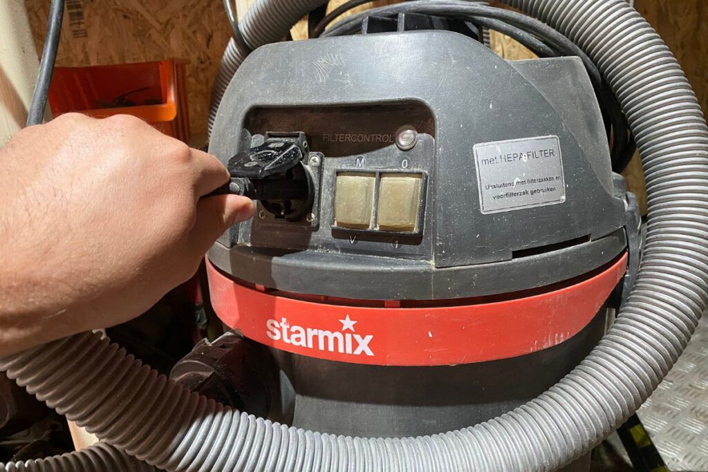 Bouwstofzuiger met ingebouwd stopcontact voor elektrisch gereedschap